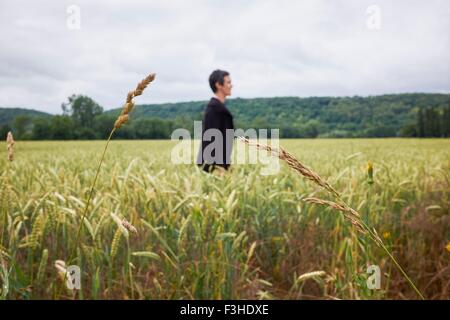 Side view of woman standing in cornfield Stock Photo