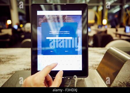 Womans hand using digital tablet touchscreen for restaurant  payment Stock Photo