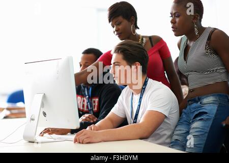 Group of students working on desktop computer in classroom Stock Photo