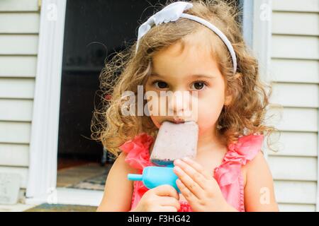 Portrait of young girl, eating ice lolly Stock Photo