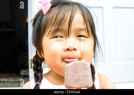 Portrait of young girl, eating ice lolly Stock Photo
