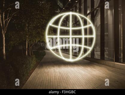 Glowing globe symbol in city at night Stock Photo