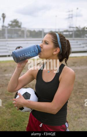 Soccer player drinking in field Stock Photo