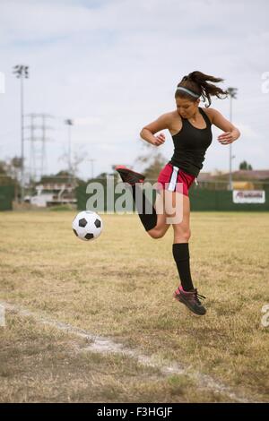 Soccer player practising in field Stock Photo