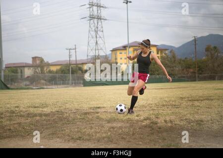 Soccer player practising in field Stock Photo