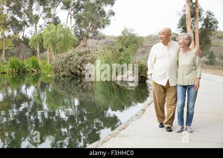 Senior couple walking beside lake Stock Photo