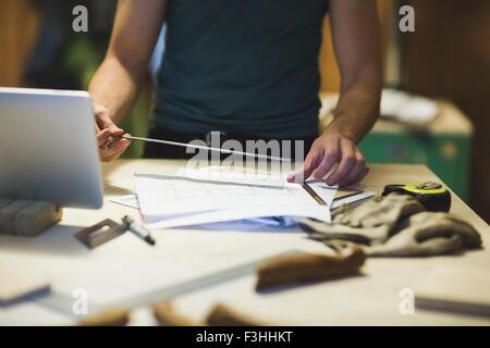 Cropped view of young mans hands using ruler Stock Photo