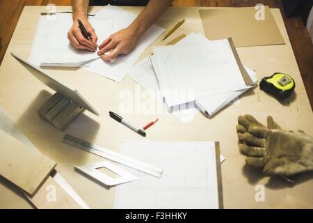 High angle view of desk and young man's hands writing Stock Photo