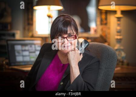 Portrait of senior woman in office, using telephone Stock Photo