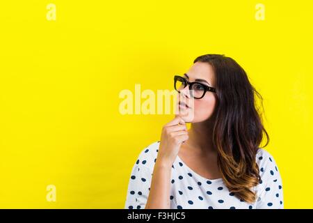 Portrait of young woman, hand on chin in thoughtful pose Stock Photo
