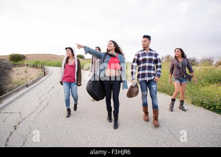 Young man and four adult sisters walking along rural road Stock Photo