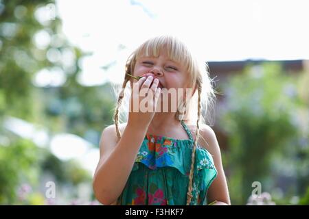 Portrait of girl eating a fresh strawberry in garden Stock Photo