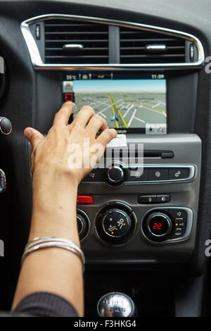 Woman sitting in car, using gps, focus on hand Stock Photo