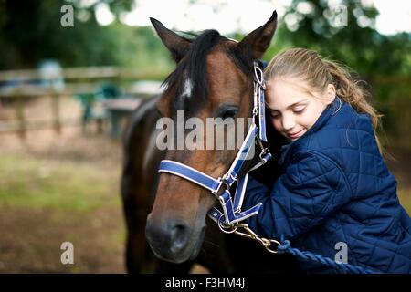 Girl horseback rider hugging horse Stock Photo