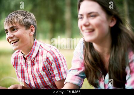 Teenage brother and sister laughing in woodland Stock Photo