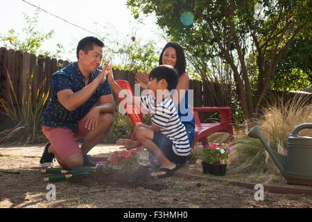 Father and son giving high five in garden Stock Photo