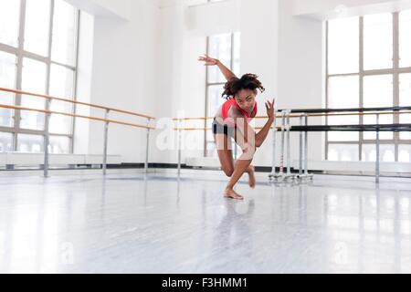 Young woman in dance studio dancing looking at camera Stock Photo