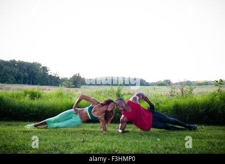 Young couple training doing side push ups in unity Stock Photo