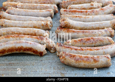 Pictured pork sausages placed in two vertical rows are cooked on the grill. Stock Photo