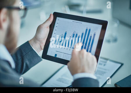 Businessman analyzing chart and graph showing changes on the market Stock Photo