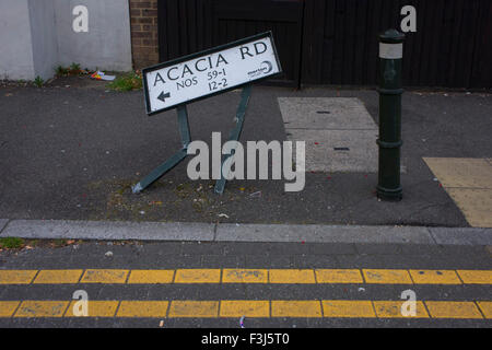 A bent street sign for Acacia Road in Mitcham, London borough of Merton. Stock Photo