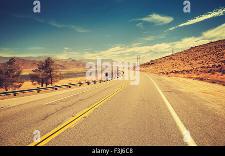 Retro old film style country highway in USA, travel adventure concept.