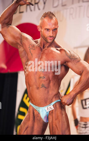 SCHIEDAM, THE NETHERLANDS - APRIL 26, 2015. Male bodybuilder Anthony Oosterlaag shows his best front pose on stage at the 38th D Stock Photo