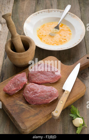 Preparing three servings of meat in egg batter Stock Photo