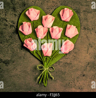 Pink roses in a heart shape on vintage wooden background Stock Photo