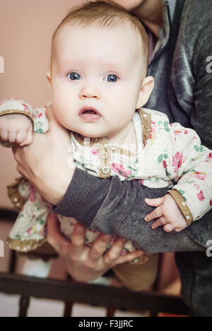 Cute baby girl in mother's arms. Babycare theme. Stock Photo