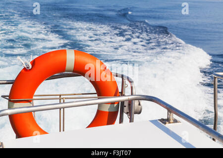 Red lifebuoy hanging on stern of fast safety rescue boat Stock Photo