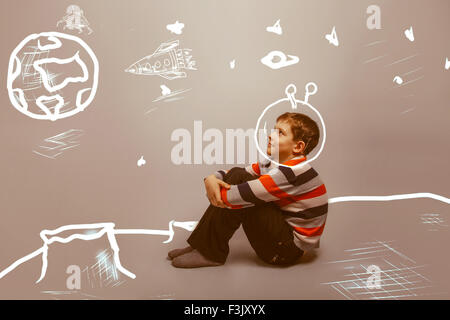 teenager boy sitting on the moon astronaut in space planet earth Stock Photo