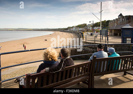 UK, England, Yorkshire East Riding, Filey, visitors sat on benches above beach and Coble Landing Stock Photo