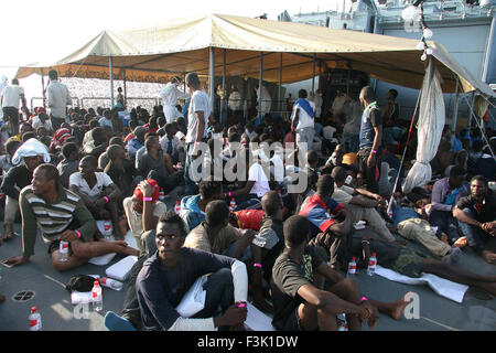 Tripoli, Libya. 05th Oct, 2015. HANDOUT - A handout picture made available on 08 October 2015 by the German armed forces shows shipwrecked people sitting on the deck of German navy frigate 'Schleswig-Holstein', around 30 nautical miles northeast of Tripoli, Libya, 05 October 2015. Photo: Alexander Gottschalk/Bundeswehr/dpa (ATTENTION EDITORS: FOR EDITORIAL USE ONLY/MANDATORY CREDIT: 'Photo: Alexander Gottschalk/Bundeswehr/dpa')/dpa/Alamy Live News Stock Photo