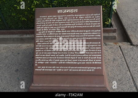 The explanation detail monument information board in Hindi white text on red stone at the entrance to the Mughal Taj Mahal Agra Stock Photo