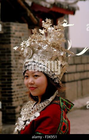 Lijiang, China:   Young Chinese woman wearing traditional Naxi clothing with ornate hand-tooled and crafted silver headress Stock Photo