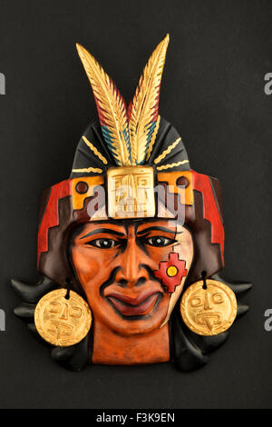 Indian Mayan Aztec ceramic mask with feather isolated on black paper background Stock Photo