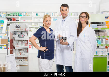 Confident Pharmacists With Digital Tablet Standing In Pharmacy Stock Photo