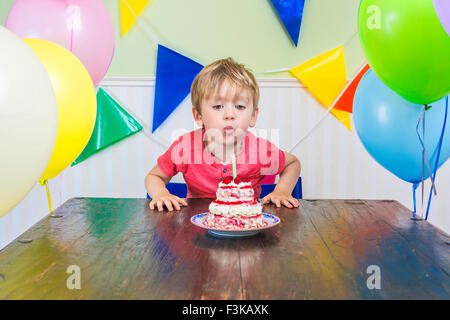 Cute kid blowing out a birthday candle Stock Photo