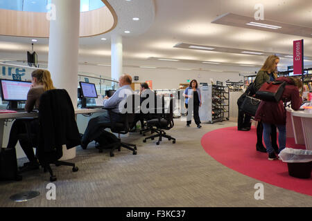A group of people using computers and laptops to connect to the Internet in the Liverpool Library, Liverpool, Merseyside, UK Stock Photo