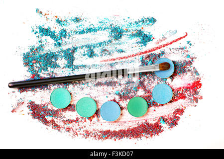 Abstract still life with crushed multicolored  eye shadows and brush on white background Stock Photo