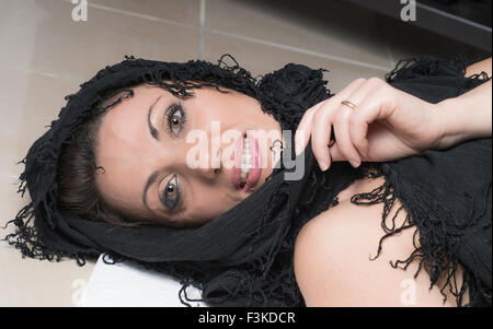 woman with face wrapped in a black shawl Stock Photo