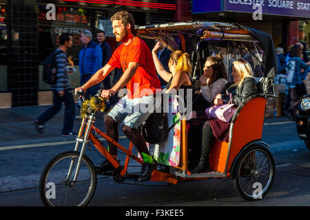 A Group of Women Travelling In A Pedicab, Leicester Square, London, UK Stock Photo