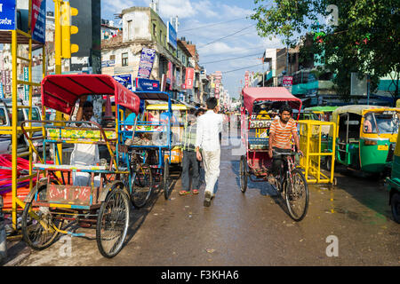 A cycle rikshaw is moving through the suburb Paharganj in front of New Delhi Railway Station Stock Photo