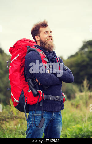 smiling man with backpack and binocular outdoors Stock Photo