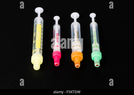 Four different pharmaceutical phials for medical use, displayed on a black table Stock Photo