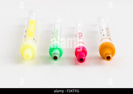 Four different pharmaceutical phials for medical use, displayed on a white table Stock Photo