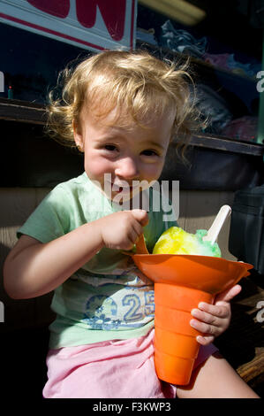 Child eating ice cream in the shop Matsumoto's Shave Ice. Haleiwa. O'ahu. Hawaii. Flavored Shave Ice from Matsumoto's Grocery St Stock Photo