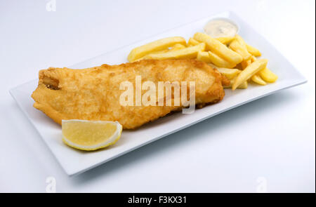 Isolated fish and chips with a wedge of lemon and tartar sauce on a white plate Stock Photo