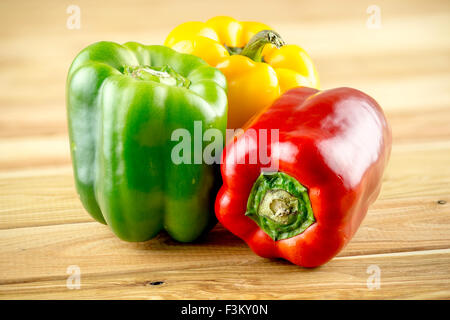 Red yellow and green peppers on wooden background Stock Photo